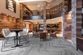 a lobby of a hotel with chairs and tables